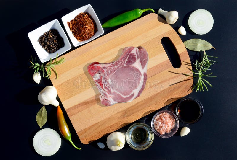 Стейк мяса на разделочной доске и перце, лист залива, розмариновом масле, луках, соли, оливковом масле, соевом соусе стоковое изображение Стейк мяса на разделочной доске и перце, лист залива, розмариновом масле, луках, соли, оливковом масле, соевом соусе стоковое изображение