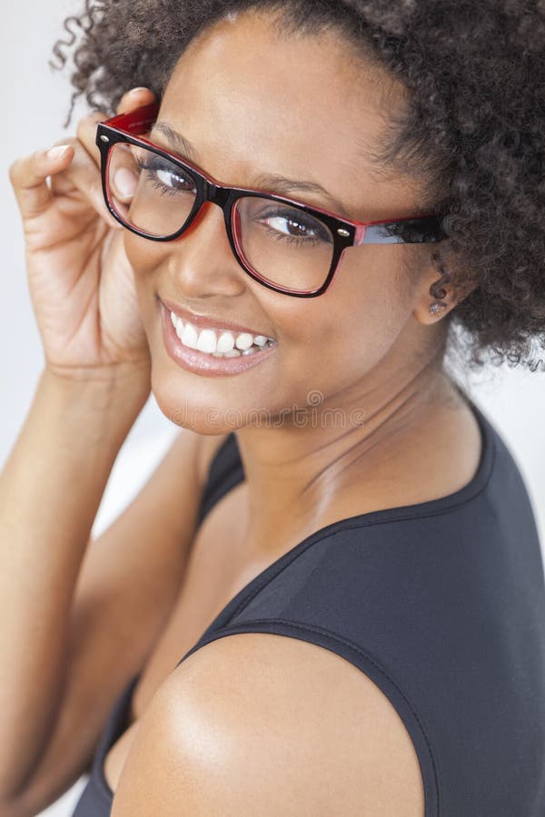 A beautiful intelligent mixed race African American girl or young woman looking happy and wearing geek glasses. A beautiful intelligent mixed race African American girl or young woman looking happy and wearing geek glasses