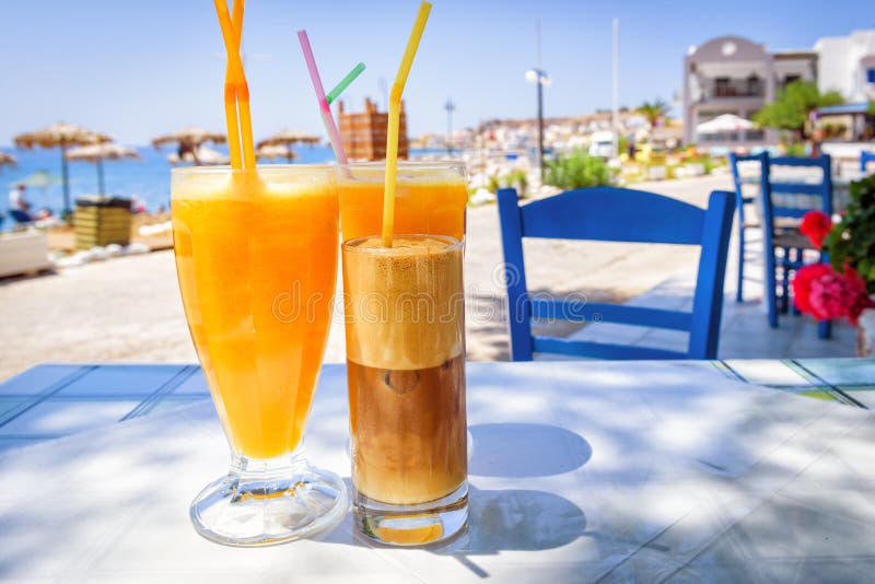 Стекла с апельсиновым соком и греческим frappe кофе стоковые фотографии rf Стекла с апельсиновым соком и греческим frappe кофе стоковые фотографии rf