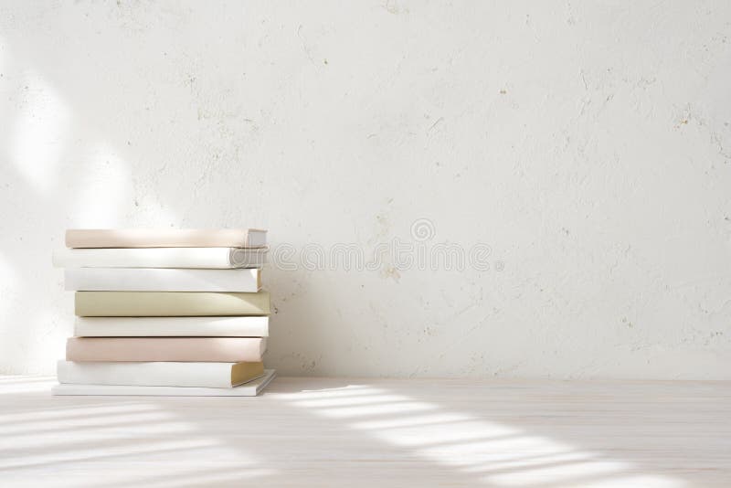 стек книг со светлыми тенями из окна на деревянном столе стоковое фото rf
