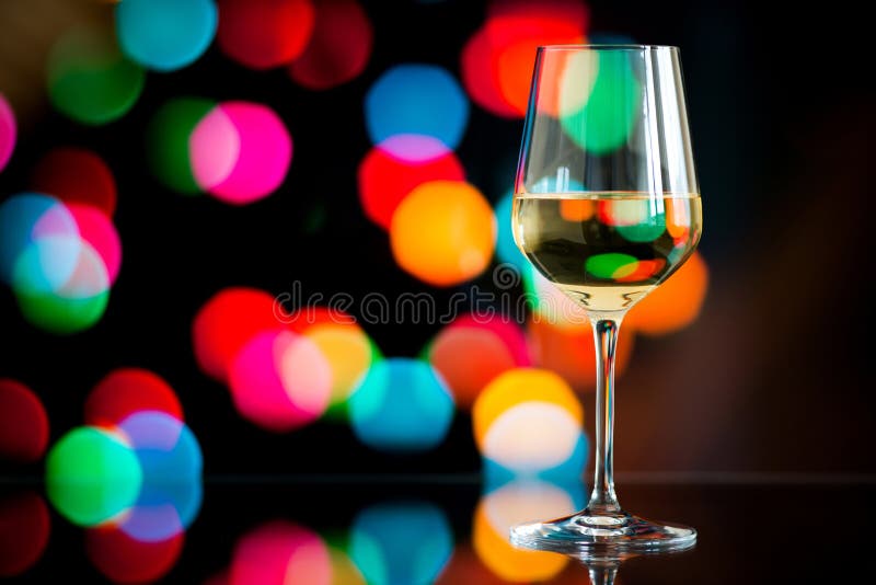 Стекло белого вина против накаляя bokeh - скопируйте космос, отборный стоковое фото rf Стекло белого вина против накаляя bokeh - скопируйте космос, отборный стоковое фото rf