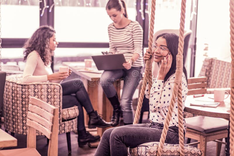 стекла Темн-с волосами фрилансера нося проводя ее день в очень творческий coworking стоковое изображение стекла Темн-с волосами фрилансера нося проводя ее день в очень творческий coworking стоковое изображение