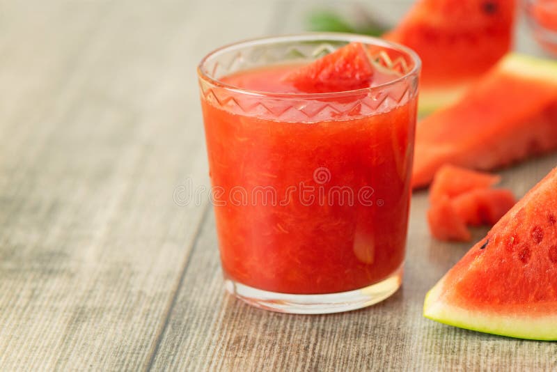 Стекло smoothie арбуза со свежими кусками арбуза на серой деревянной предпосылке стоковые фотографии rf Стекло smoothie арбуза со свежими кусками арбуза на серой деревянной предпосылке стоковые фотографии rf