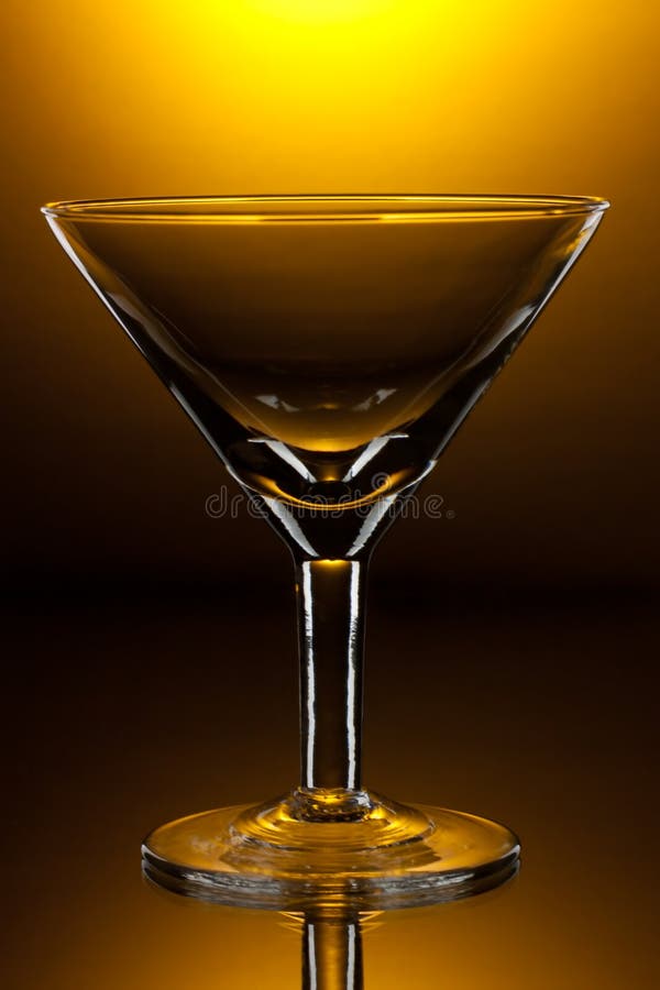 Empty martini glass on shining yellow background. Empty martini glass on shining yellow background