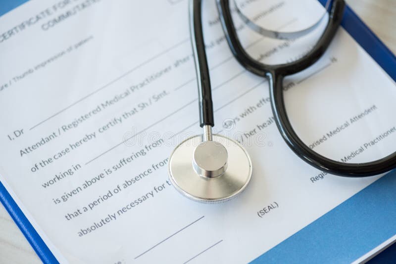 Стетоскоп лежа на доске сзажимом для бумаги с диагнозом в медицинской клинике стоковое фото Стетоскоп лежа на доске сзажимом для бумаги с диагнозом в медицинской клинике стоковое фото