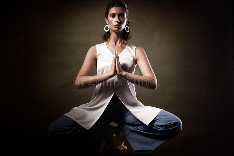 Стильная молодая атлетическая девушка в модных одеждах, показывая asanas йоги в студии Здоровье стороны и тела красоты стоковая фотография