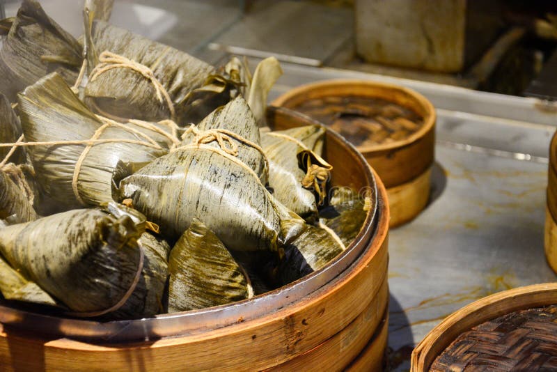 Стог испаренных китайских вареников или zongzi в бамбуковой корзине, липком рисе в оболочке в бамбуковом разрешении для фестиваля стоковое фото rf Стог испаренных китайских вареников или zongzi в бамбуковой корзине, липком рисе в оболочке в бамбуковом разрешении для фестиваля стоковое фото rf