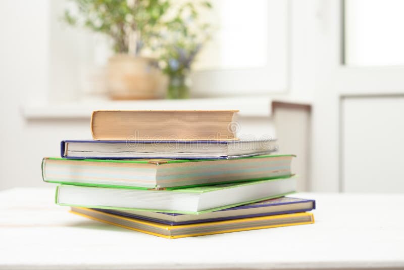 Стог книг на белой таблице стоковое изображение rf Стог книг на белой таблице стоковое изображение rf