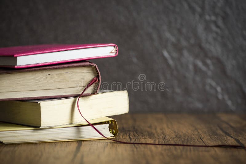 Стог книги на деревянном столе с темной черной предпосылкой/книгами в концепции образования библиотеки стоковые фотографии rf Стог книги на деревянном столе с темной черной предпосылкой/книгами в концепции образования библиотеки стоковые фотографии rf