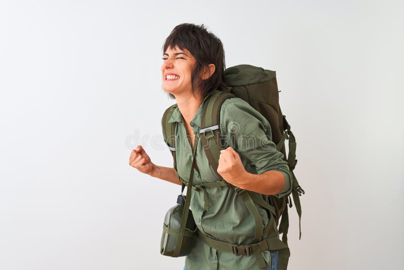 Столовая рюкзака и красивой женщины hiker с более изолированной белым фоном очень счастлив и взволнован, что победитель стоковое фото rf