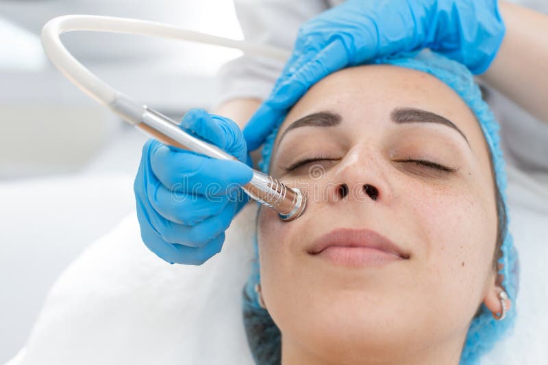 Сторона microdermabrasion диаманта процедуре по Beautician терпеливая Маленькая девочка проходит курс процедур спа в офисе стоковые фотографии rf Сторона microdermabrasion диаманта процедуре по Beautician терпеливая Маленькая девочка проходит курс процедур спа в офисе стоковые фотографии rf