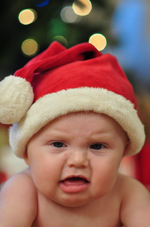 Cranky Faced Baby Girl in santa outfit for christmas. Cranky Faced Baby Girl in santa outfit for christmas