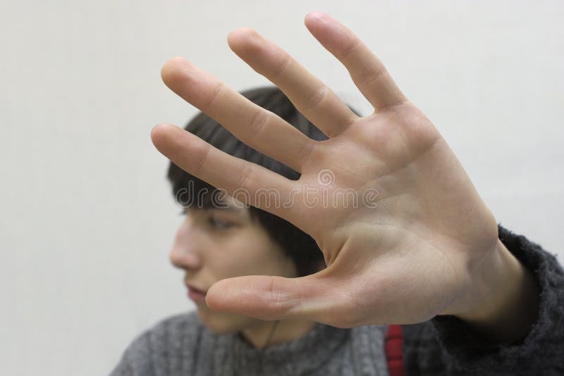 Teenager hides his face by hand. Teenager hides his face by hand.