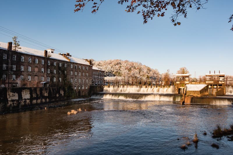 Prattville, Alabama, USA - December 9, 2017: Historic Pratt Cotton Gin Company and spillway in downtown Prattville after a rare snow storm. Prattville, Alabama, USA - December 9, 2017: Historic Pratt Cotton Gin Company and spillway in downtown Prattville after a rare snow storm.