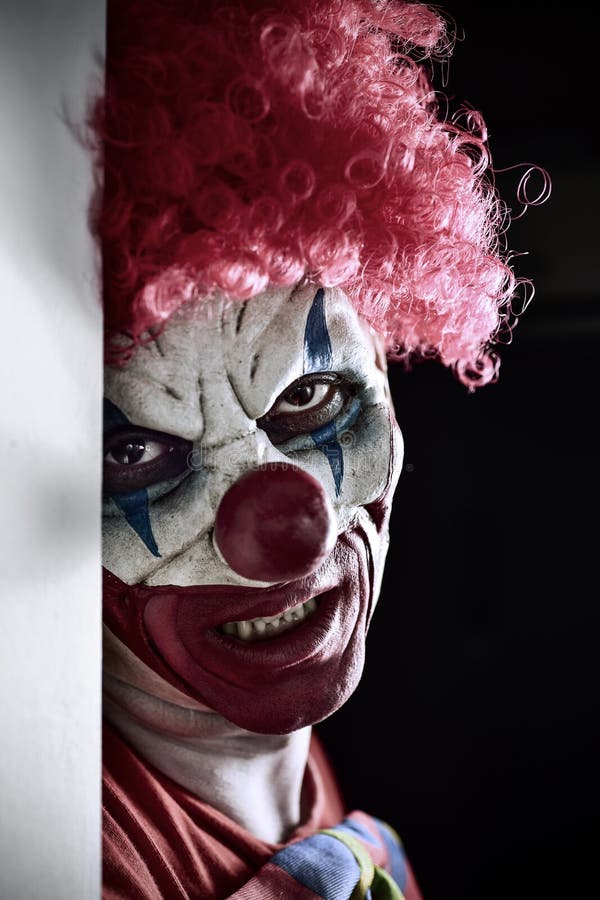 Portrait of a scary evil clown against a dark background. Portrait of a scary evil clown against a dark background