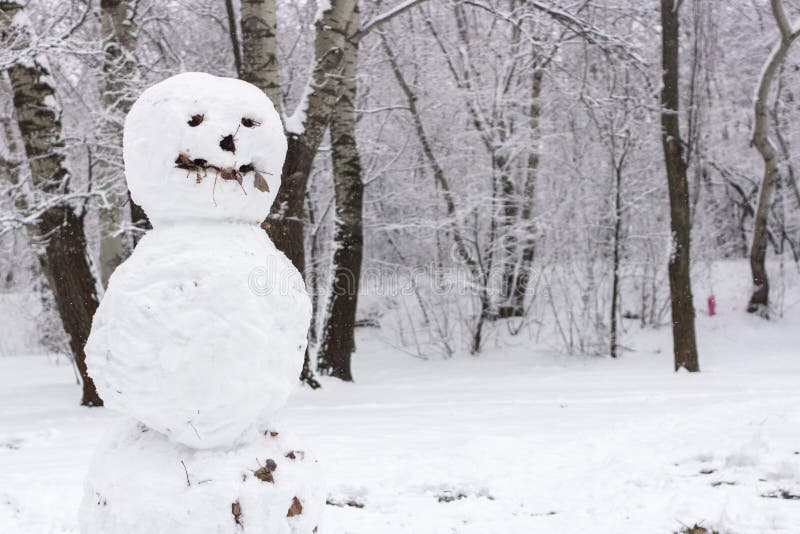 Sculpture of snow. Strange and terrifying snowman. Playing outdoors in winter. Family winter fun in the forest. Smile and nose of a snowman. Winter vacation. Frosty weather. Snow man in the park. Sculpture of snow. Strange and terrifying snowman. Playing outdoors in winter. Family winter fun in the forest. Smile and nose of a snowman. Winter vacation. Frosty weather. Snow man in the park.