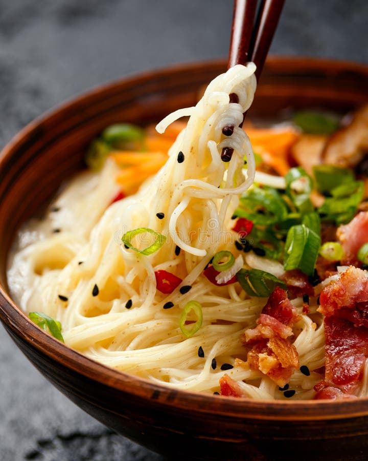 Pork bone Japanese style ramen noodle soup with crispy bacon, shiitake mushrooms and spring onions in clay bowl. Pork bone Japanese style ramen noodle soup with crispy bacon, shiitake mushrooms and spring onions in clay bowl.