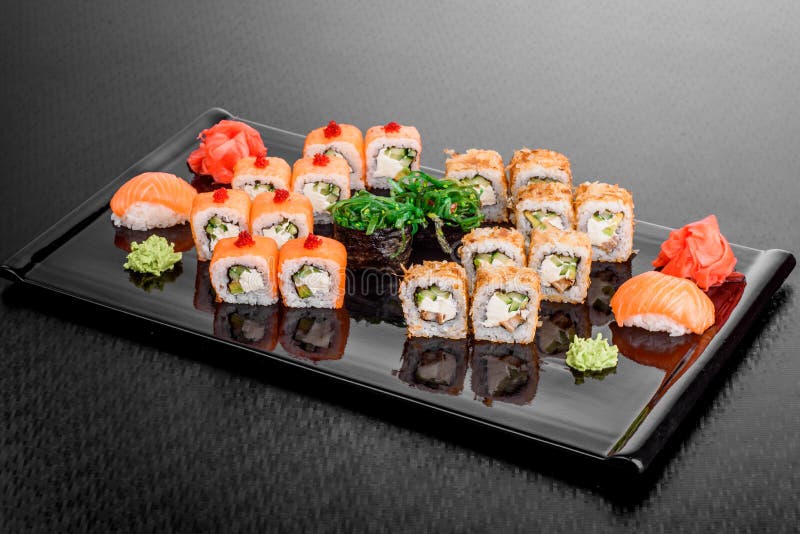 Суши Maki установили на темную предпосылку картины Nigiri, крены и сасими суш установленные служили в черной квадратной плите стоковая фотография rf Суши Maki установили на темную предпосылку картины Nigiri, крены и сасими суш установленные служили в черной квадратной плите стоковая фотография rf