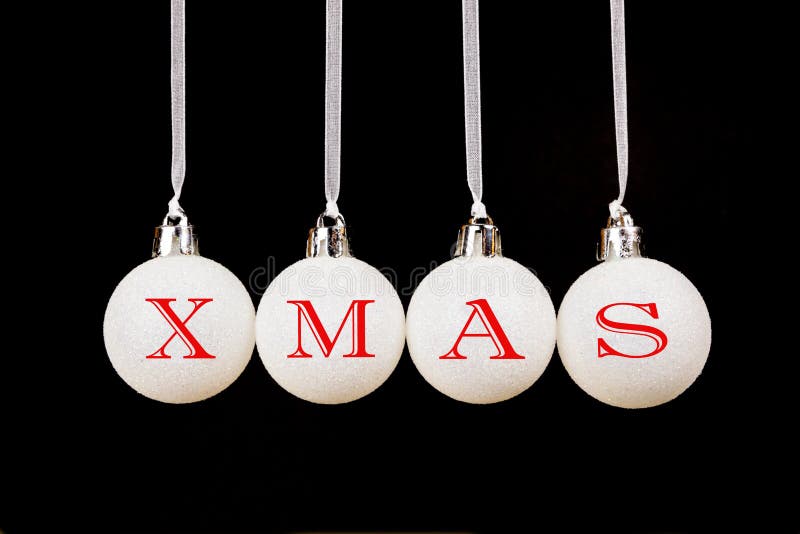Word XMAS on white christmas balls hanging in a horizontal row isolated on black background. Word XMAS on white christmas balls hanging in a horizontal row isolated on black background