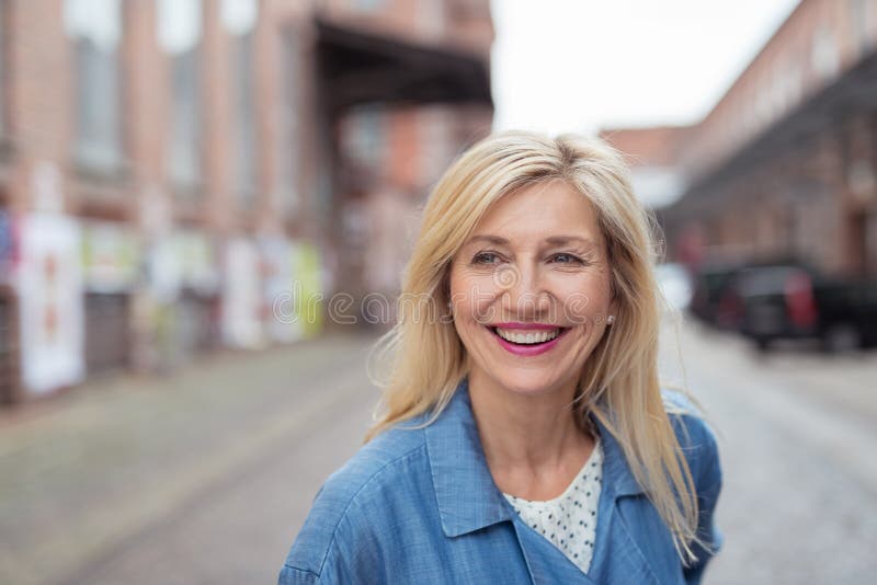 Close up Happy Adult Woman with Long Blond Hair, Laughing While Walking at the City Street. Close up Happy Adult Woman with Long Blond Hair, Laughing While Walking at the City Street