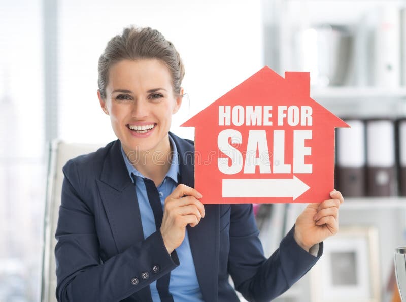 Happy realtor woman showing home for sale sign in office. Happy realtor woman showing home for sale sign in office