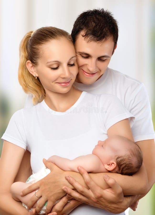 Счастливая молодая семья матери, отца и newborn младенца в их a стоковое фото rf