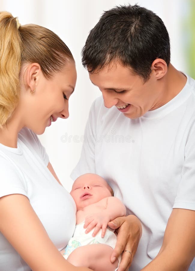 Счастливая молодая семья матери, отца и newborn младенца в их a стоковые фотографии rf