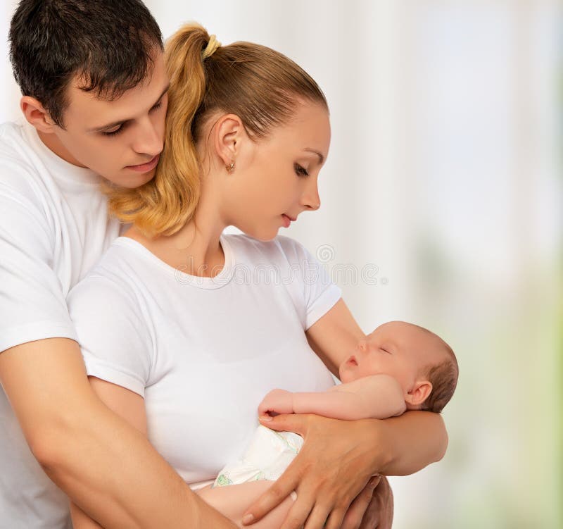 Счастливая молодая семья матери, отца и newborn младенца в их a стоковое изображение rf