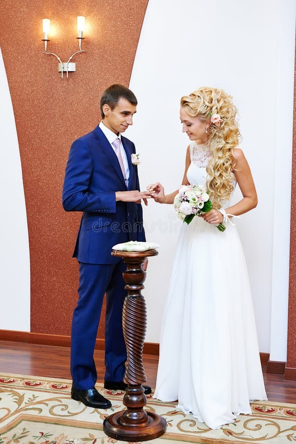 Счастливая невеста носит обручальное кольцо ее groom стоковое изображение rf Счастливая невеста носит обручальное кольцо ее groom стоковое изображение rf