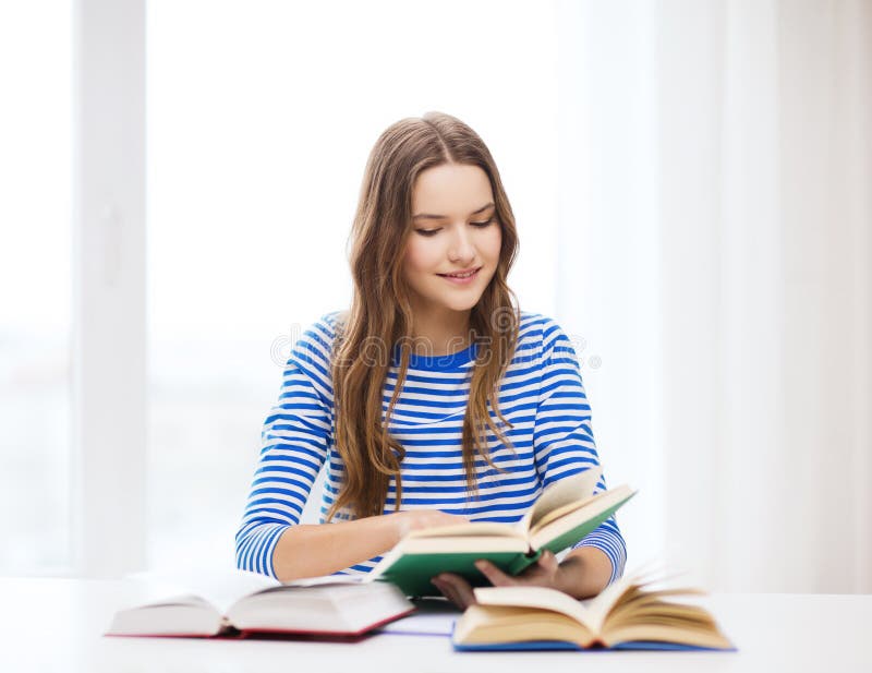 Счастливая усмехаясь девушка студента с книгами стоковые фото