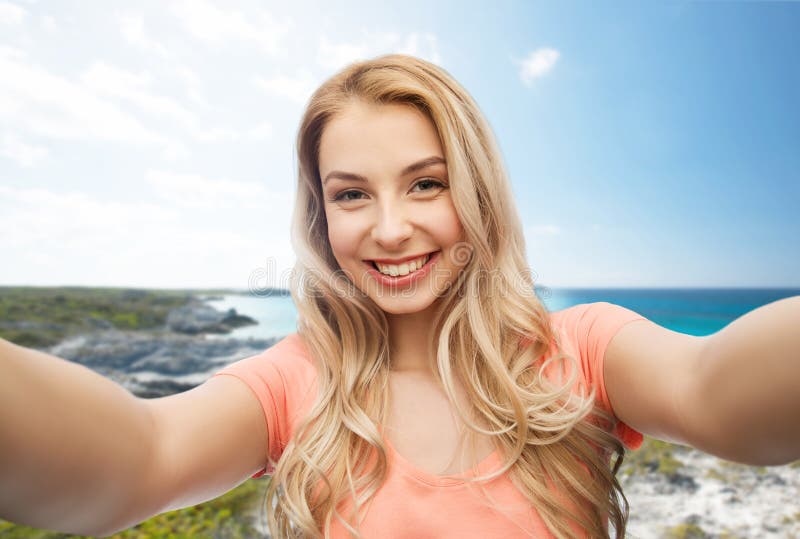 Счастливая усмехаясь молодая женщина принимая selfie стоковые изображения rf