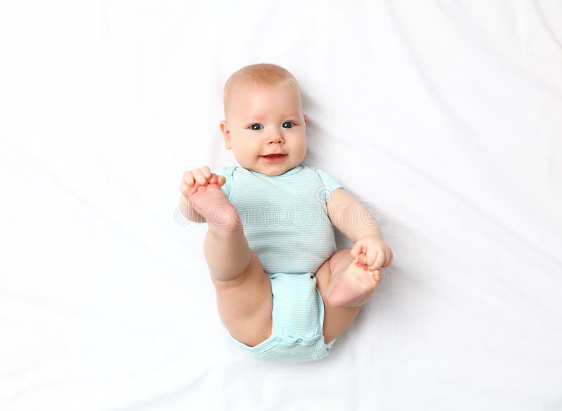 Счастливый newborn младенец на кровати стоковое фото rf