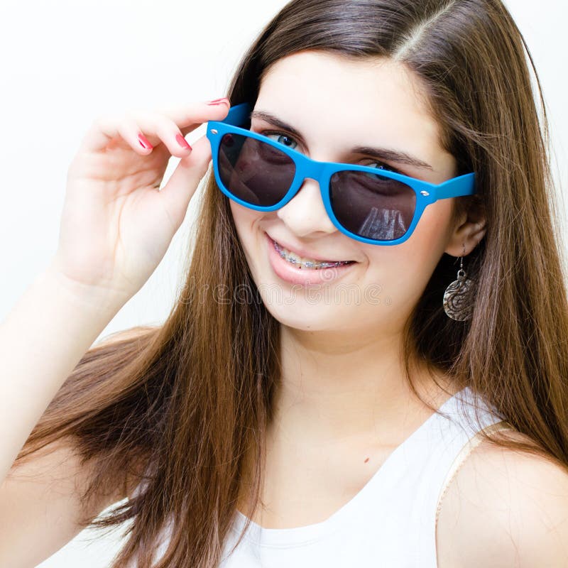 Happy teenage girl wearing braces & shades funny smiling isolated over white background. Happy teenage girl wearing braces & shades funny smiling isolated over white background