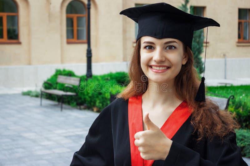 Счастливая женщина на ее университете выпускного дня Образование и люди стоковые изображения rf Счастливая женщина на ее университете выпускного дня Образование и люди стоковые изображения rf