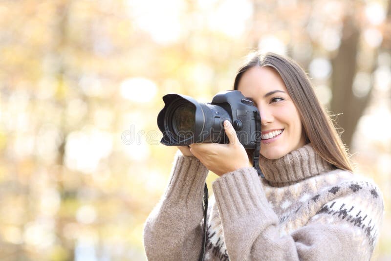 счастливая женщина фотографирует с помощью камеры dslr в природе стоковые фото