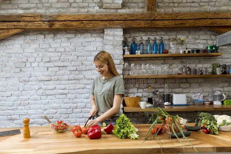 Счастливая молодая женщина готовит вкусную и здоровую пищу на кухне в лофте дома стоковые фото Счастливая молодая женщина готовит вкусную и здоровую пищу на кухне в лофте дома стоковые фото