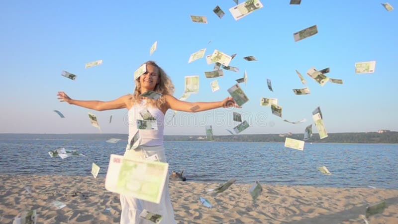 Счастливая молодая женщина и деньги падая от неба