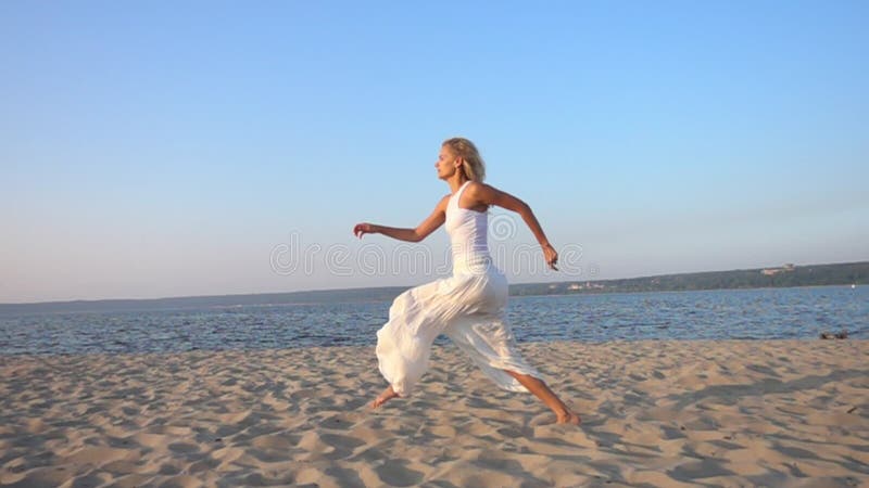 счастливая молодая красивая женщина бежать и скача на пляж