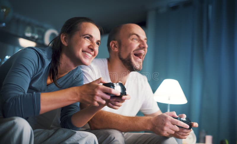 счастливая пара играет в видеоигры дома стоковые изображения rf