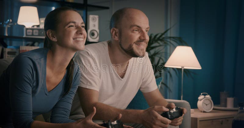 счастливая пара играет в видеоигры дома стоковые фотографии rf