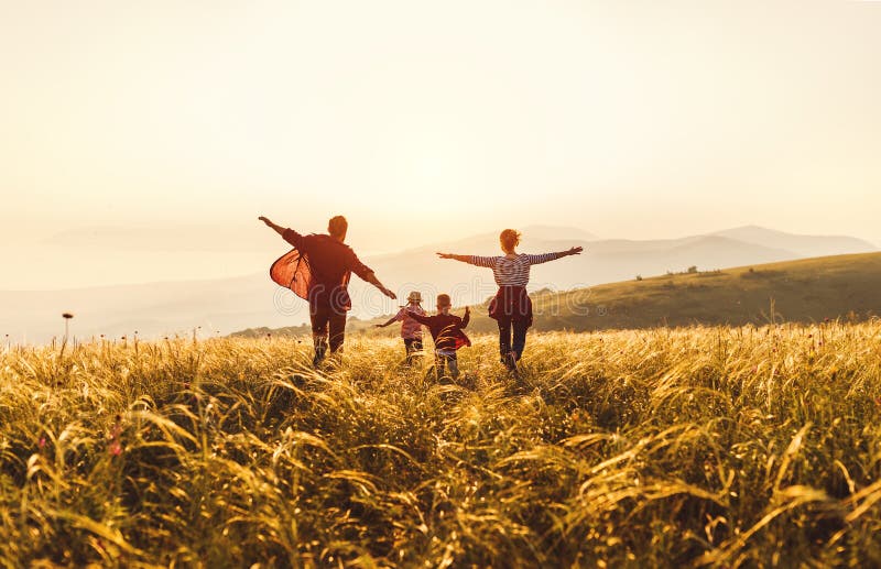 Happy family: mother, father, children son and  daughter runing and jumping on nature  on sunset. Happy family: mother, father, children son and  daughter runing and jumping on nature  on sunset