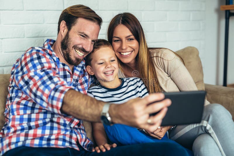 Счастливая семья используя цифровую таблетку принимая selfie стоковое фото rf
