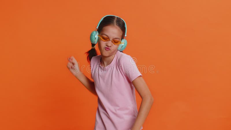 Счастливая улыбающаяся девочка-дочка слушает музыку, танцуя дискотеку, развлекаясь в помещении видеоматериал