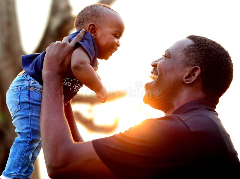 Father's Day. A Happy African American father and son at the park at sunset. Father's Day. A Happy African American father and son at the park at sunset.