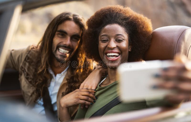 Счастливые молодые пары с selfie с мобильным смартфоном при изготовлении езды- людей, путешествия, весело управление в машине стоковое изображение rf