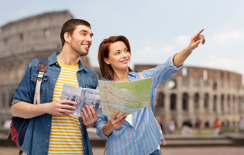 Travel, tourism and vacation concept - happy couple of tourists with city guide, map and backpacks over coliseum background. Travel, tourism and vacation concept - happy couple of tourists with city guide, map and backpacks over coliseum background