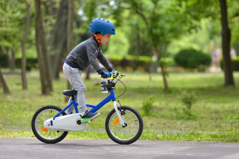 Счастливый мальчик ребенк 5 лет имея парк потехи весной с bicycl стоковая фотография rf Счастливый мальчик ребенк 5 лет имея парк потехи весной с bicycl стоковая фотография rf