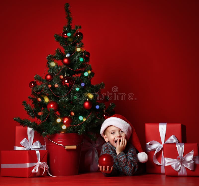 счастливый новый год xmas Портрет ребенка в подарках рождества красной шляпы Санта ждать стоковое изображение счастливый новый год xmas Портрет ребенка в подарках рождества красной шляпы Санта ждать стоковое изображение