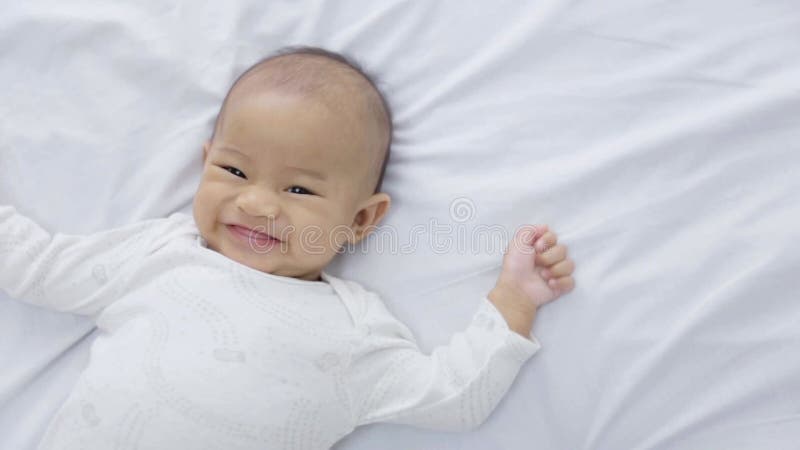счастливый ребенок лежит на кровати