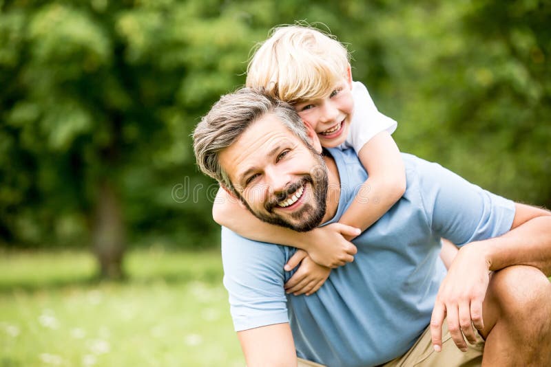 Happy father and son together hugging in summer. Happy father and son together hugging in summer